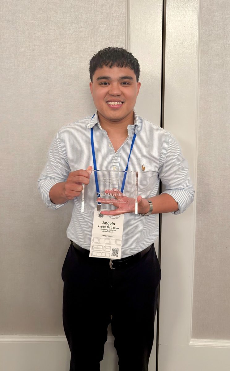 Angelo De Castro holding the ADSA Purina poster competition award