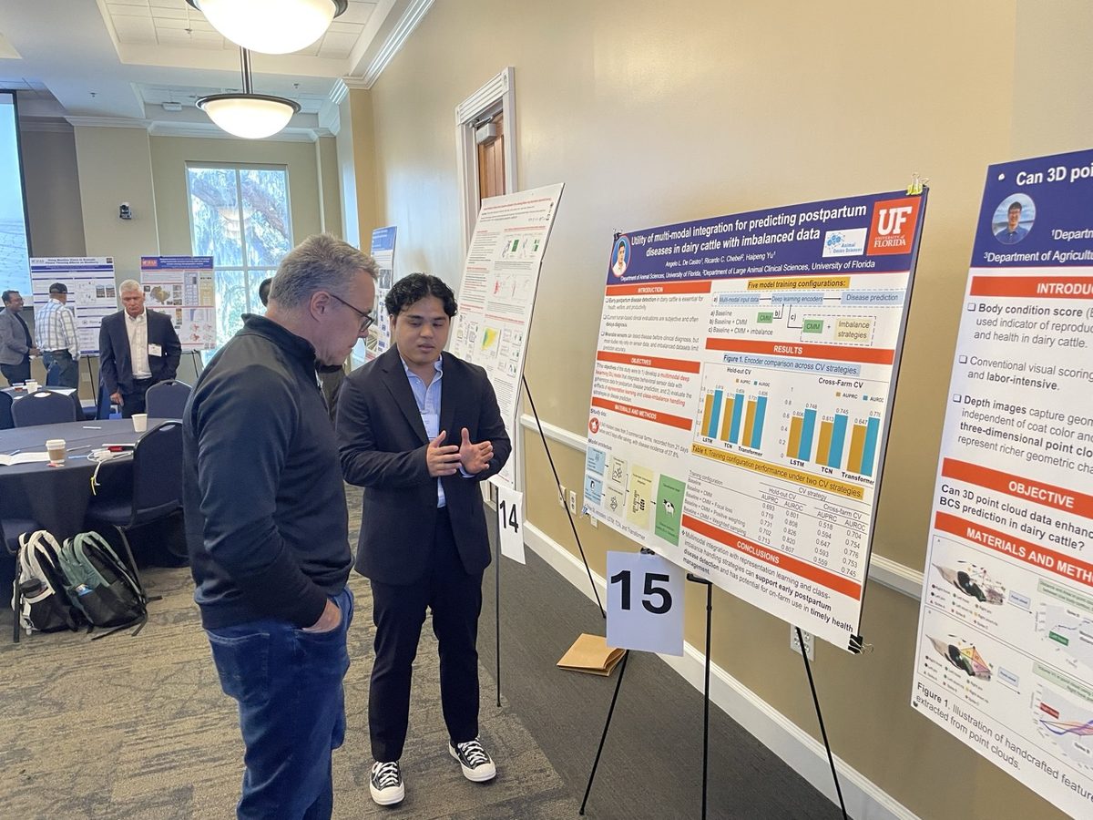 Angelo De Castro discussing his poster with an attendee
