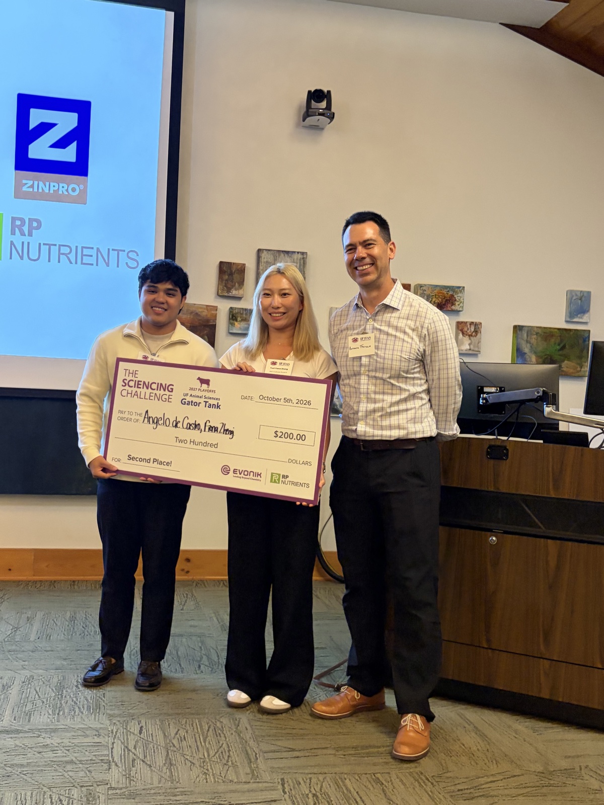 Angelo De Castro and Yuxi Zhang receiving the Gator Tank second place check from Dr. Antonio Faciola