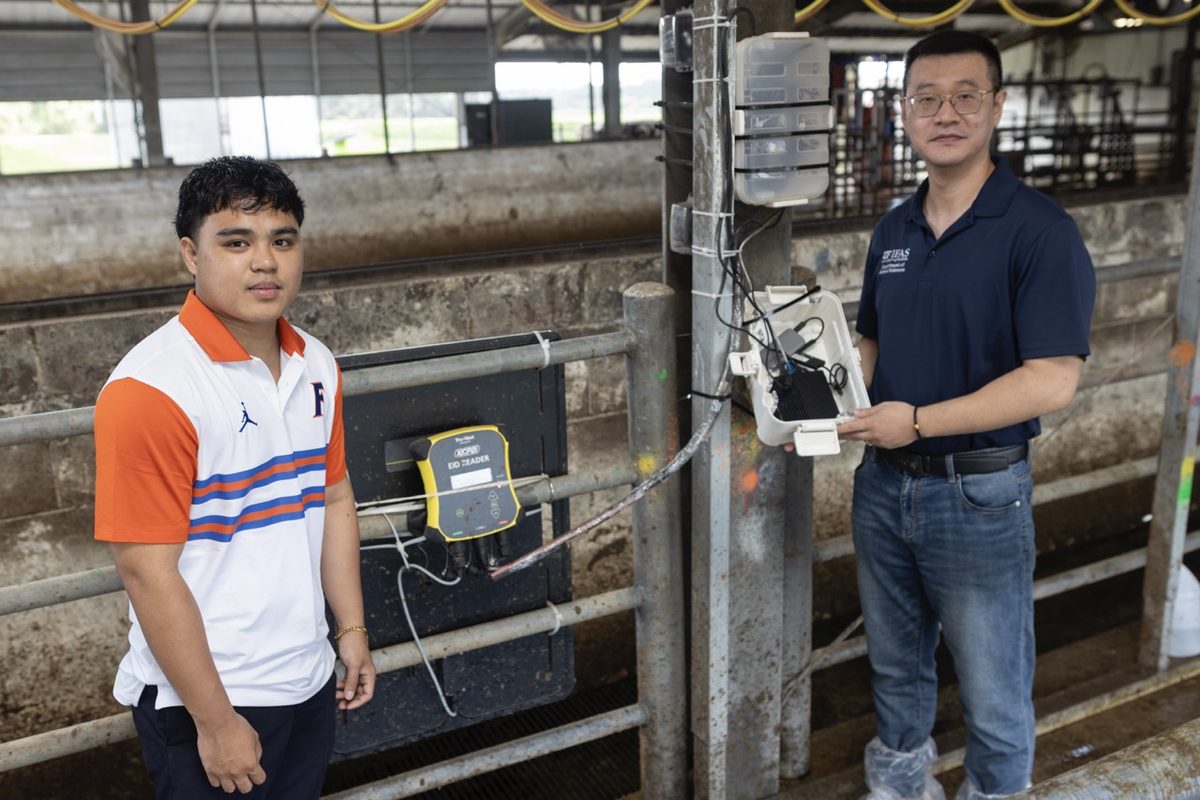 Angelo De Castro with Dr. Haipeng Yu next to farm sensor equipment